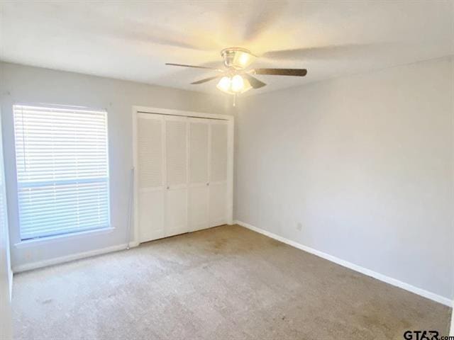 unfurnished bedroom with ceiling fan, baseboards, a closet, and carpet