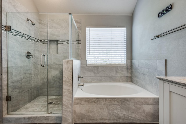 bathroom featuring a shower stall, vanity, and a bath