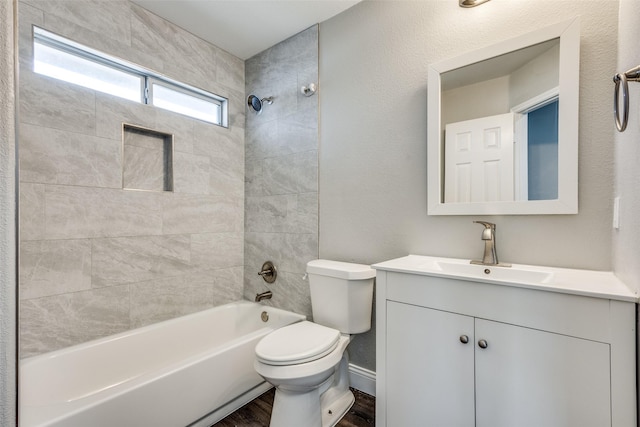 bathroom featuring wood finished floors, shower / bathing tub combination, vanity, and toilet