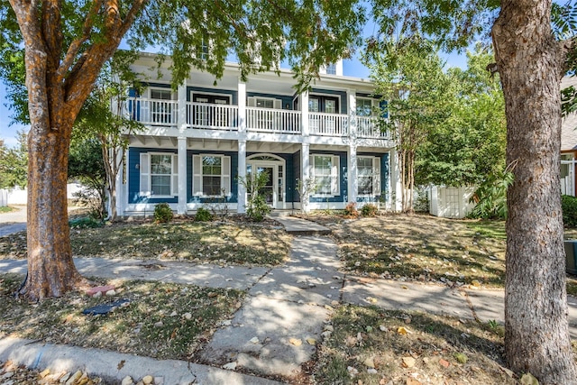 view of front of home featuring fence and a balcony