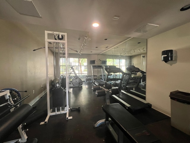 gym with baseboards and track lighting