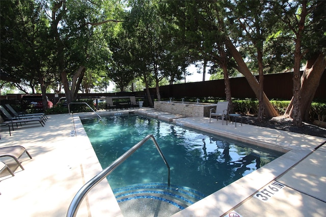 community pool featuring a patio and a fenced backyard