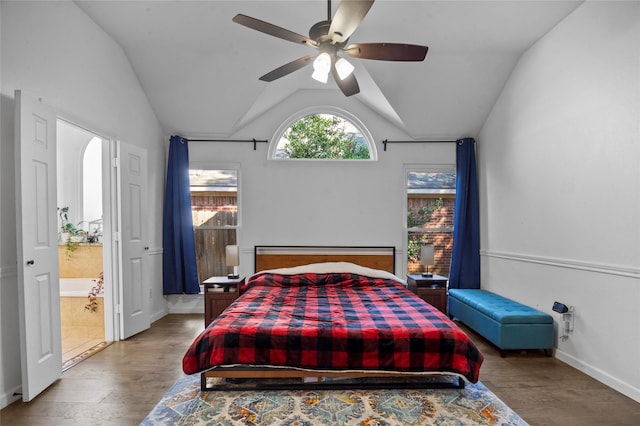 bedroom featuring lofted ceiling, wood finished floors, a ceiling fan, baseboards, and ensuite bath