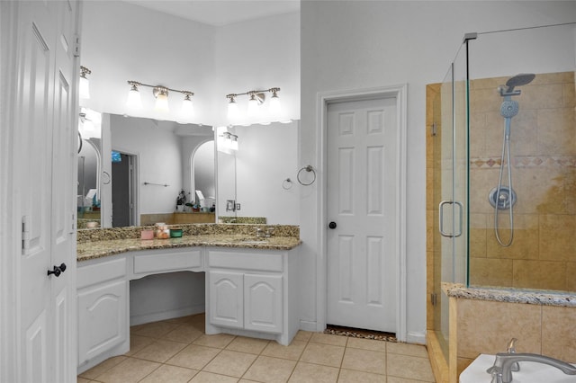 bathroom with a stall shower, vanity, and tile patterned floors