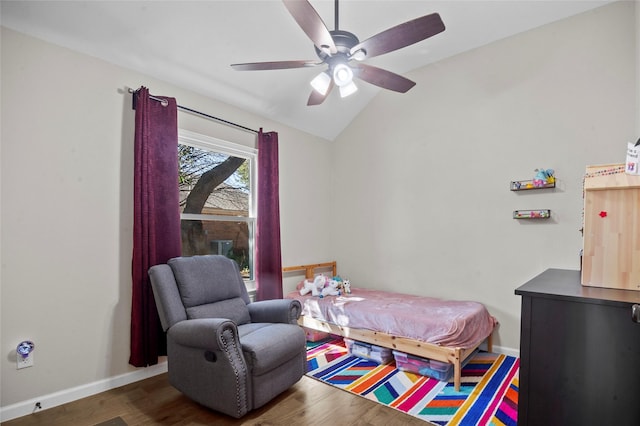 bedroom with ceiling fan, vaulted ceiling, baseboards, and wood finished floors