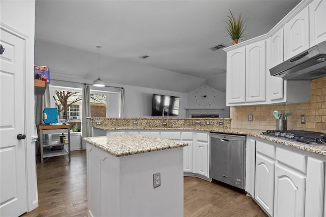 kitchen with stainless steel appliances, visible vents, a peninsula, wood finished floors, and under cabinet range hood