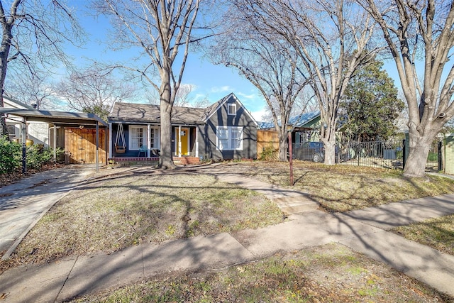 english style home featuring covered porch, fence, and concrete driveway