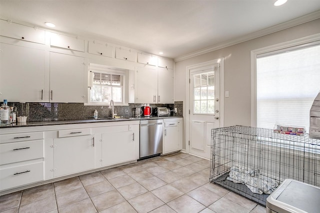 kitchen featuring dark countertops, white cabinetry, dishwasher, and a sink