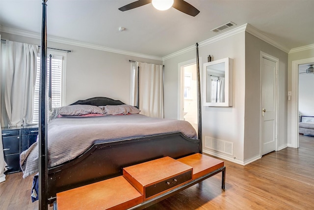 bedroom featuring baseboards, crown molding, visible vents, and wood finished floors