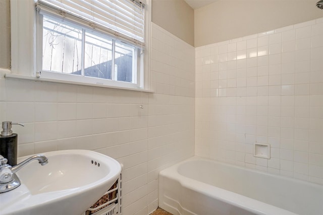 bathroom with tile walls and a sink