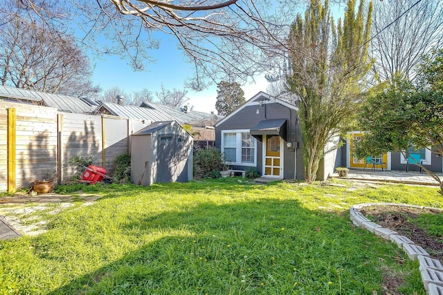 view of yard with a shed, an outdoor structure, and fence