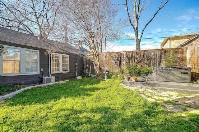 view of yard with a patio area, fence, and a hot tub