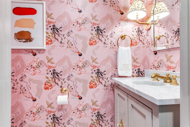 bathroom featuring vanity and wallpapered walls