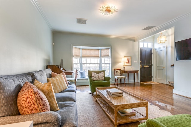 living room with visible vents, crown molding, baseboards, and wood finished floors