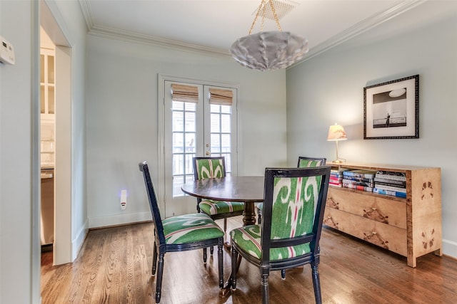 dining space with ornamental molding, french doors, baseboards, and wood finished floors