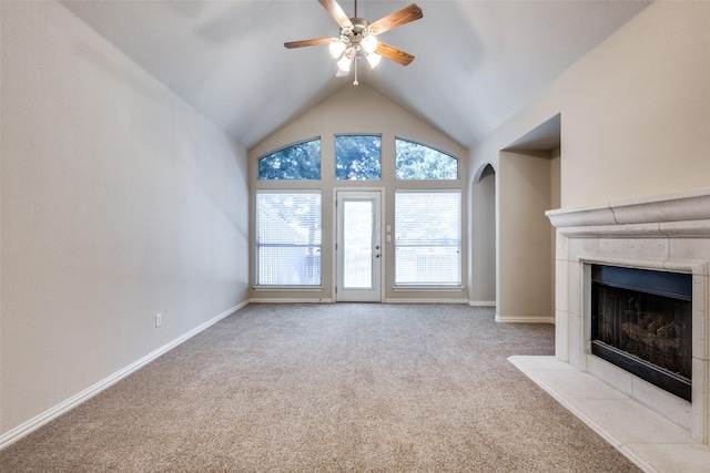 unfurnished living room with baseboards, a tile fireplace, ceiling fan, carpet floors, and high vaulted ceiling