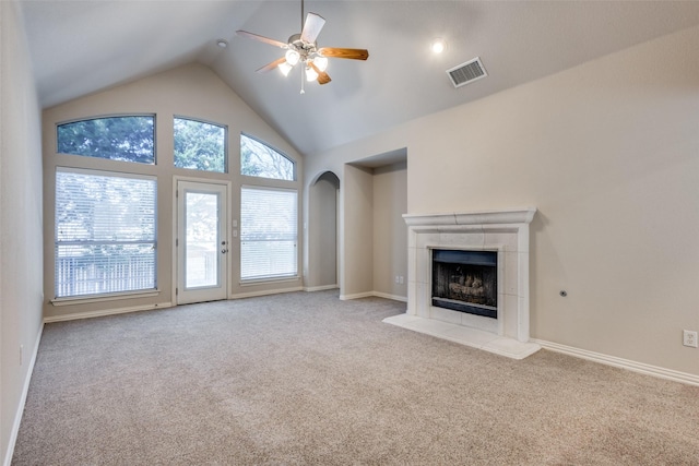 unfurnished living room with carpet, visible vents, a ceiling fan, a tile fireplace, and baseboards