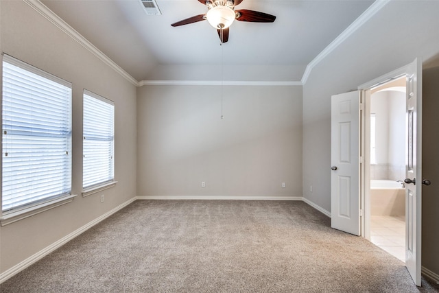 empty room featuring vaulted ceiling, carpet, a ceiling fan, and crown molding