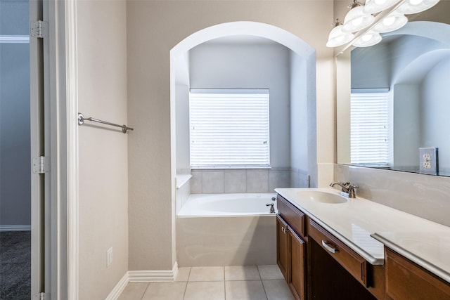 bathroom with a garden tub, vanity, and tile patterned floors