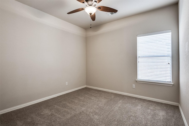 spare room featuring carpet, visible vents, ceiling fan, and baseboards