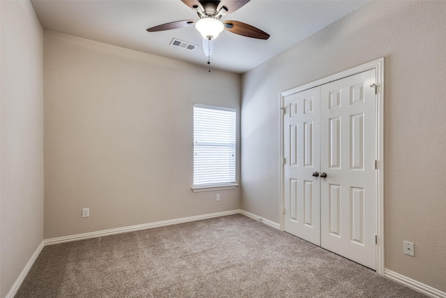 unfurnished bedroom featuring baseboards, a closet, visible vents, and carpet flooring