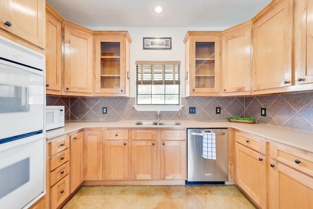 kitchen with white appliances, light countertops, a sink, and light brown cabinetry