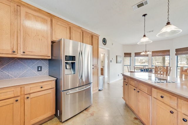 kitchen featuring light brown cabinets, tasteful backsplash, stainless steel fridge, and visible vents