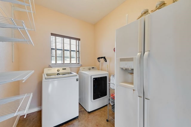 clothes washing area featuring laundry area, baseboards, and washing machine and clothes dryer