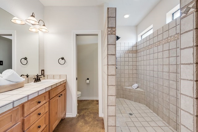 full bathroom featuring baseboards, vanity, toilet, and a walk in shower