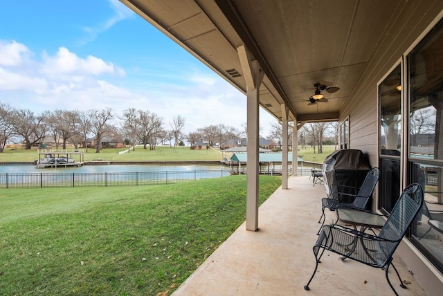 view of patio / terrace with a water view, a grill, fence, and a ceiling fan