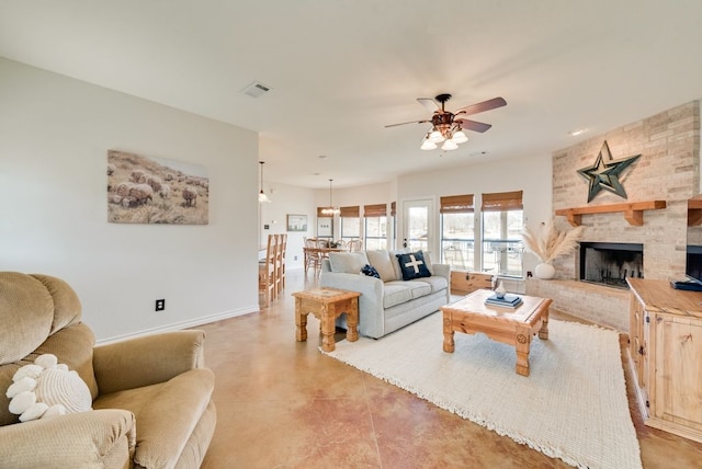 living area with ceiling fan, a fireplace, visible vents, and baseboards