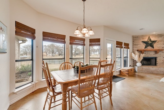 dining room featuring a fireplace and an inviting chandelier