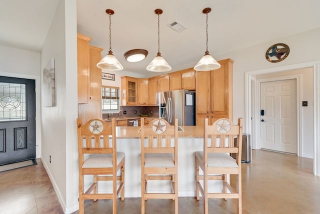 kitchen with stainless steel appliances, visible vents, light countertops, backsplash, and a kitchen breakfast bar