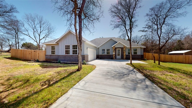 view of front of home featuring driveway, an attached garage, fence, board and batten siding, and brick siding