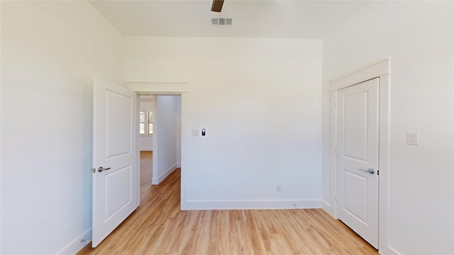 unfurnished room with light wood-style floors, baseboards, visible vents, and ceiling fan