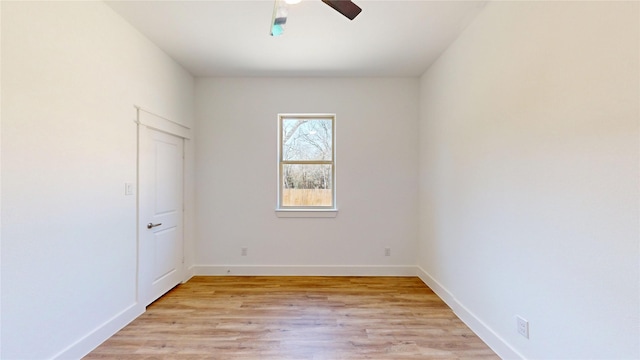 spare room with light wood finished floors, baseboards, and a ceiling fan