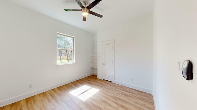 unfurnished bedroom with ceiling fan, light wood-style flooring, and baseboards