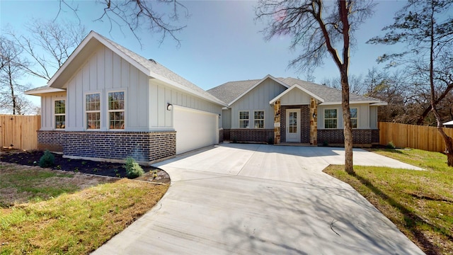 view of front of property with an attached garage, fence, board and batten siding, and brick siding