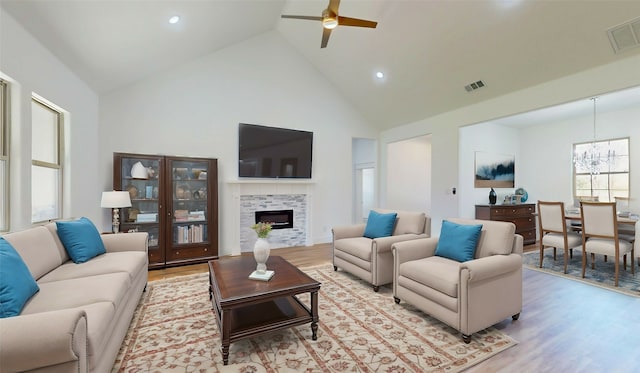 living area featuring light wood-style flooring, visible vents, and a tiled fireplace