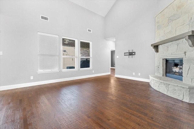 unfurnished living room with baseboards, a fireplace, visible vents, and wood finished floors