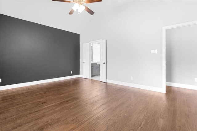 unfurnished bedroom with high vaulted ceiling, baseboards, wood finished floors, and ensuite bathroom