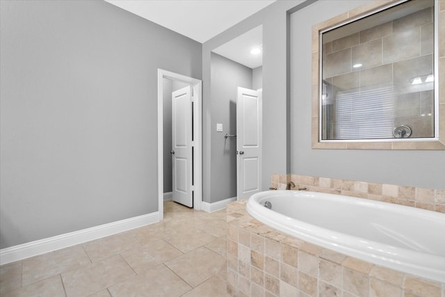 full bath featuring tile patterned flooring, tiled shower, baseboards, and a bath