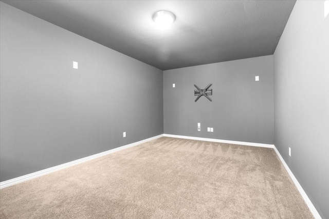 carpeted empty room featuring baseboards