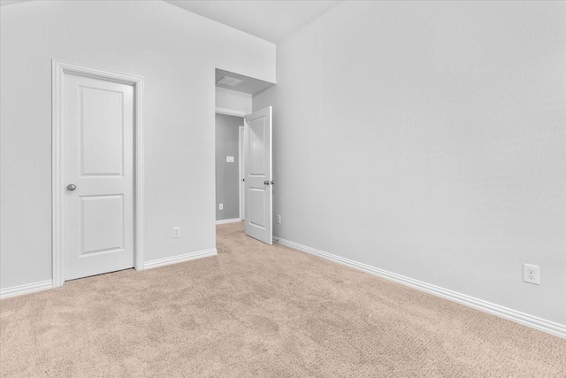 unfurnished bedroom featuring light carpet and baseboards