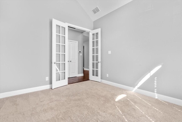 unfurnished bedroom featuring carpet, french doors, lofted ceiling, visible vents, and baseboards