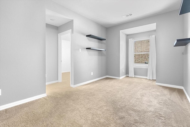 unfurnished living room with baseboards, visible vents, and carpet flooring