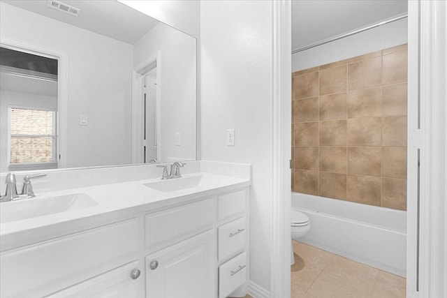 full bath with visible vents, a sink, toilet, and double vanity