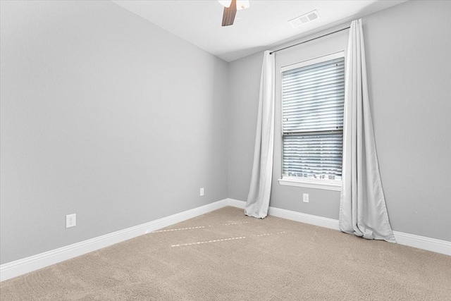 empty room with light carpet, baseboards, visible vents, and ceiling fan