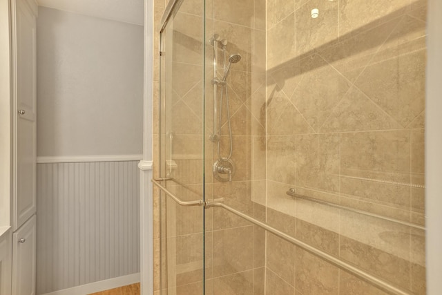 bathroom with a stall shower and wainscoting