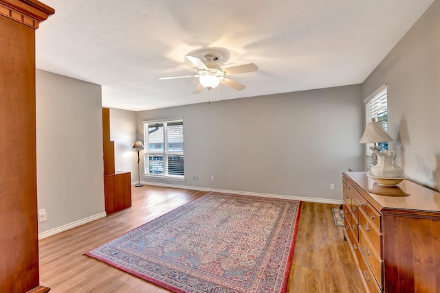 spare room with light wood-style flooring, baseboards, and ceiling fan